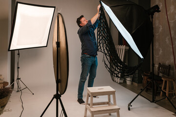 Man photographer putting grid on softbox