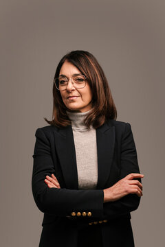 Confident businesswoman with crossed hands in studio