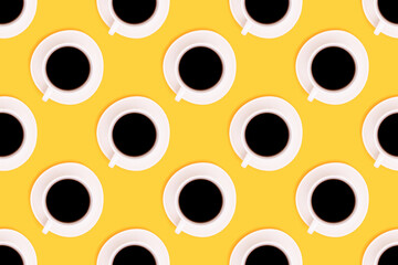 Pattern made of cup with black coffee on a yellow background. Morning drink creative concept.