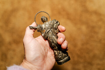 Hand holding religious figure of Saint Pancras that attracts money 