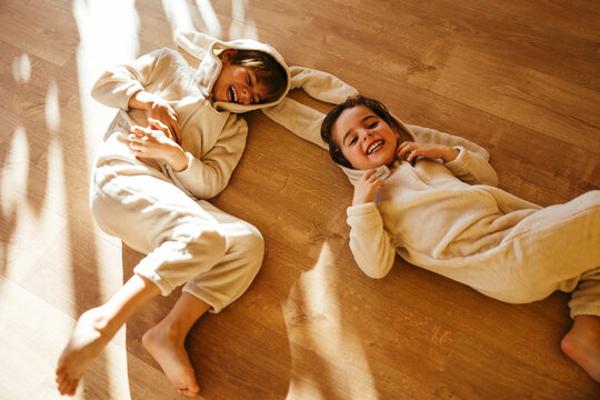 Happy brothers in Easter costume lying on floor