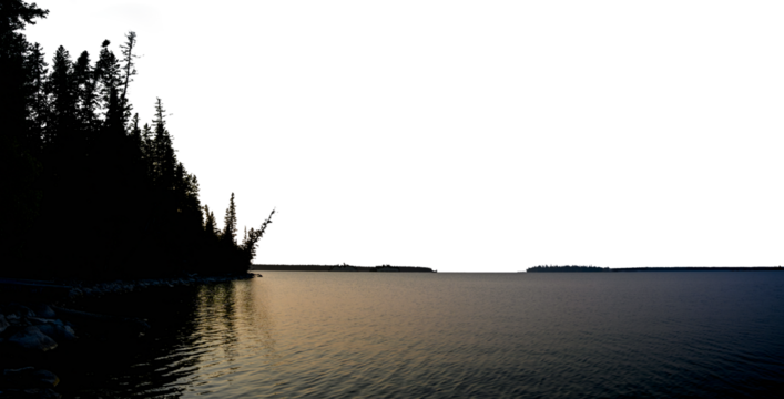 A late evening panoramic view of a calm lake with a silhouette shoreline of evergreen trees and a transparent sky. The water is reflecting the sun that is behind the tress.
- Powered by Adobe