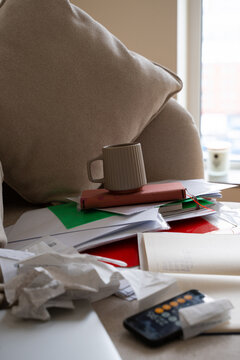 messy pile of business receipts, tax, invoices, paper on couch at home