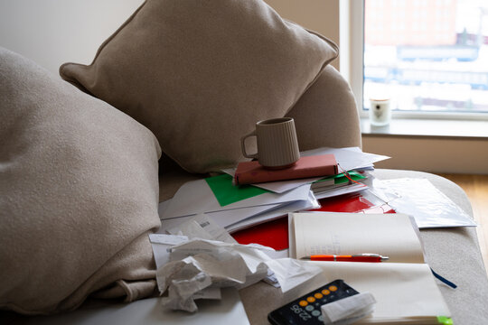 messy pile of business receipts, tax, invoices, paper on couch at home
