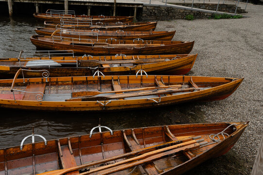 Wood boats lined up on a rocky shore