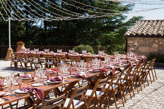 Two long elegant wedding table filled with glass, cups and tableclots