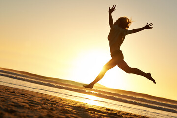 Silhouette, woman and jump at beach for sunset, happiness and celebration in nature for freedom....