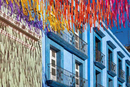 Old blue building with colored paper hanging in front 