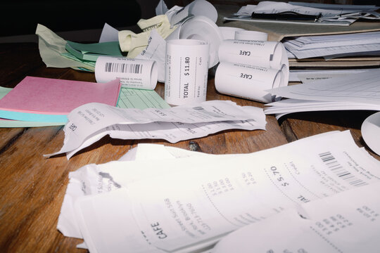 Pile of Receipts on a Wooden Table
