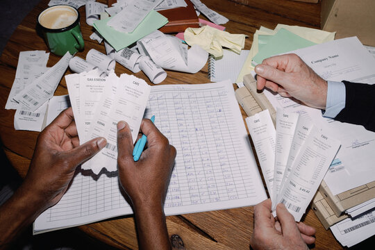 Hands Organising Receipts and Ledger
