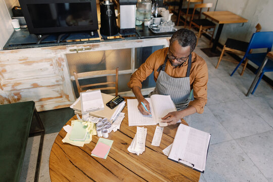 Coffee shop owner doing bookkeeping tasks
