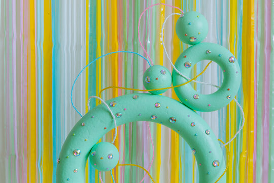 Green colored torus with with sparkles, beads on a coloured background