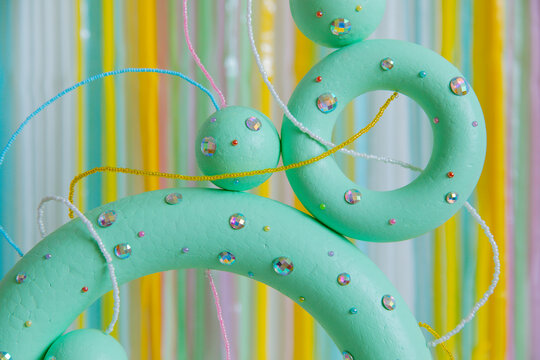 Green colored torus with with sparkles, beads on a coloured background