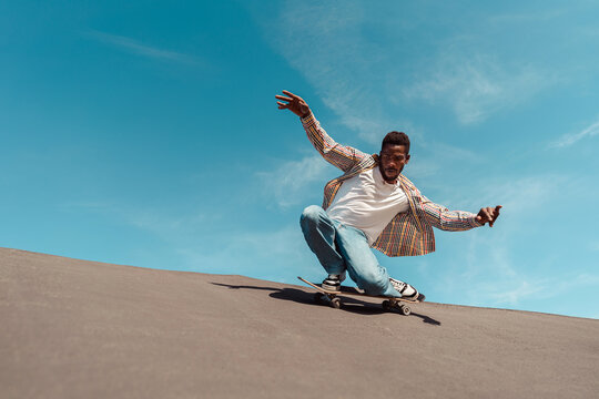 Active black man skateboarding on a ramp