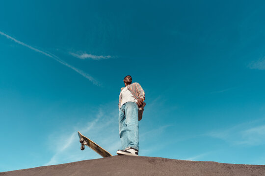 Skateboarder standing on ramp with copyspace