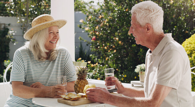 Senior, couple or pineapple on patio with water for retirement, planning vacation for anniversary. Husband, wife or old in garden for talk with drink, sunshine in summer with partner in home for chat