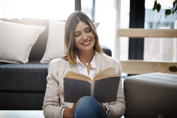 Woman, home and smile with reading book to relax on day off and leisure. Female person, holiday and...