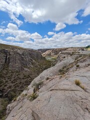 Cañón rocoso bajo cielo azul con nubes