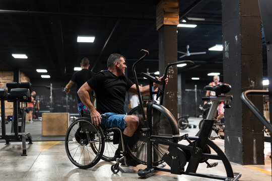 Smiling man in wheelchair working out at the gym