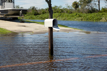 Hurricane flooded street with mail box surrounded with water in Florida residential area. Consequences of natural disaster