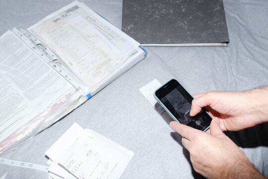 Man scanning receipts with smartphone for his business accountability