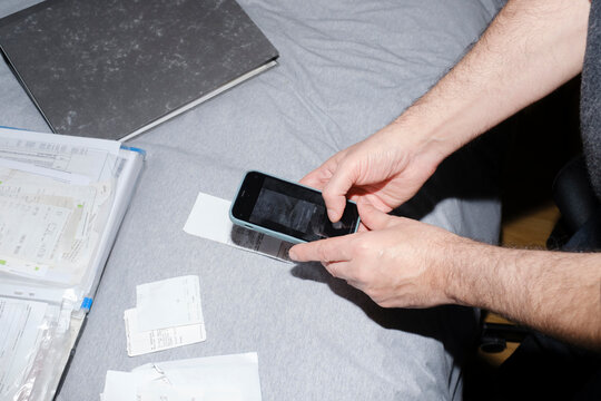 Man scanning receipts with smartphone for his business accountability
