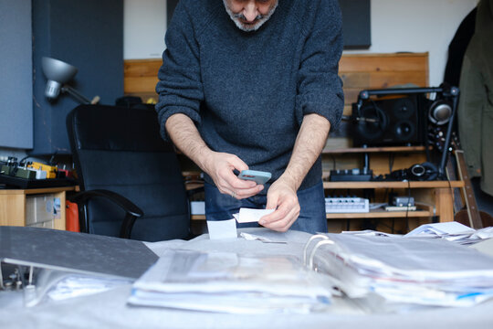 Man scanning receipts with smartphone for his business accountability