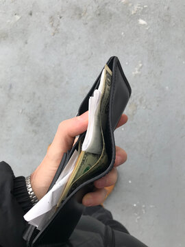 Hand Holds Wallet with money and receipt outdoor  - UGC 