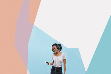 Girl, headphones and phone for streaming in studio, website and online for playlist on colorblock background. Black female person, mockup space and internet for social media, kpop and app for music