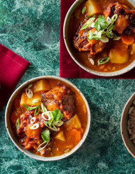 Oxtail dish in bowls on a green background