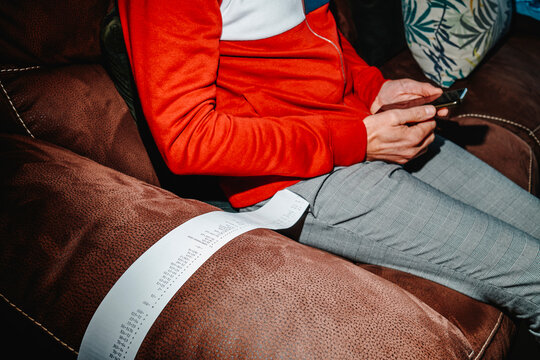 man with a strip of paper with calculations hanging from his pocket