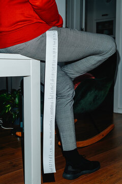 man with a long strip of paper with different calculations