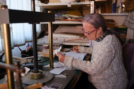 Woman organizing receipts for her business tax report in workshop