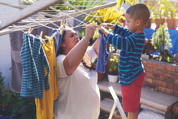 Mother, child and hanging laundry or helping in backyard for learning responsibility, washing or...