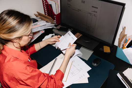 Focused Female office employee working on manages receipts, invoices