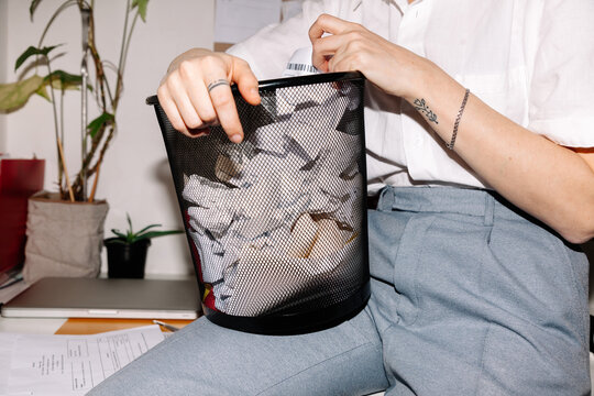 Office female worker holding trash bin