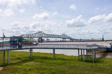 The Horace Wilkinson Bridge over the flowing waters off the Mississippi River with boats on the...