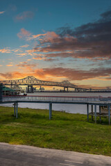 The Horace Wilkinson Bridge over the flowing waters off the Mississippi River with boats on the...