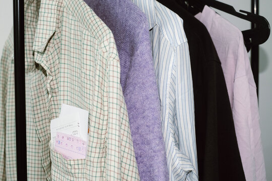 A stack of receipts sticking out of the pocket of a shirt