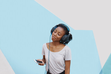 Black girl, headphones and phone for sound in studio, website and online for streaming playlist on backdrop. Female person, mockup space and internet for social media, kpop and app for music or fun