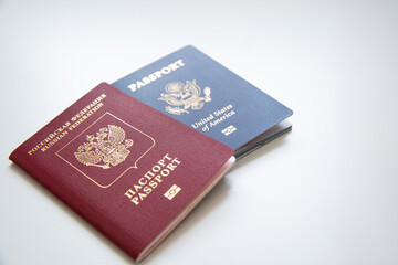 Close up of an American and a Russian passport on white table