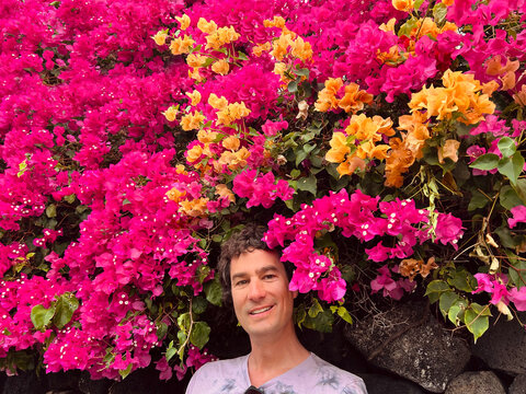Man Standing Under Bright Bougainvillea Flowers