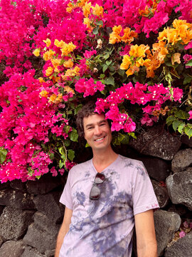 Man Standing Under Bright Bougainvillea Flowers