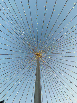 A pole with wires around it filled with small lights