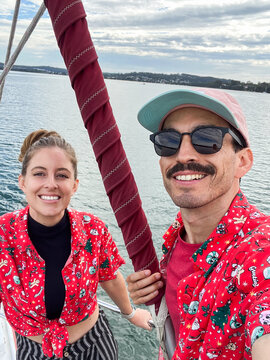 Selfie of a happy couple in Christmas T-shirts on a boat