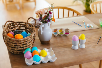 Colorful Easter eggs and flowers on wooden table