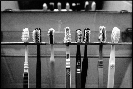 Toothbrushes hanging from a bathroom mirror