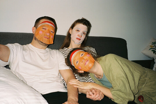 Three young friends with face masks in pyjamas 