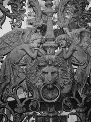 Impresionante trabajo de hierro forjado sobre puerta con &aacute;ngeles alados y cabeza de le&oacute;n