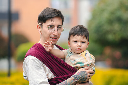 Father carrying his baby in a sling